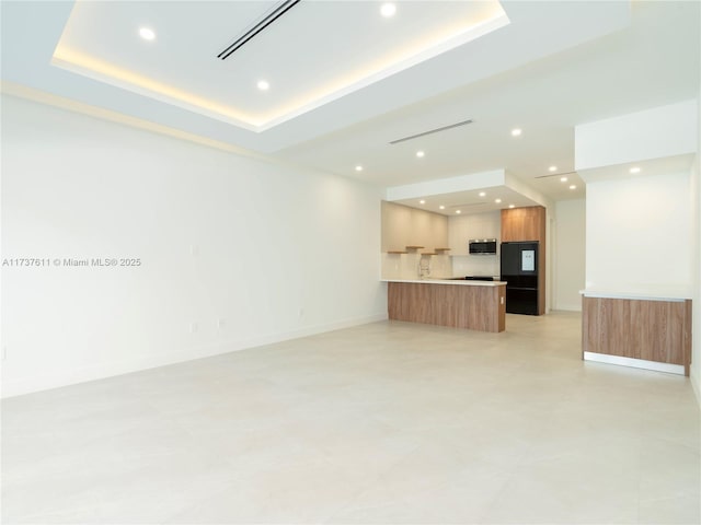 unfurnished living room featuring a raised ceiling