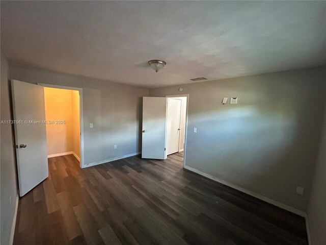 7403 Foxbloom Dr, New Port Richey, FL 34668 - unfurnished bedroom featuring dark wood-style floors and baseboards