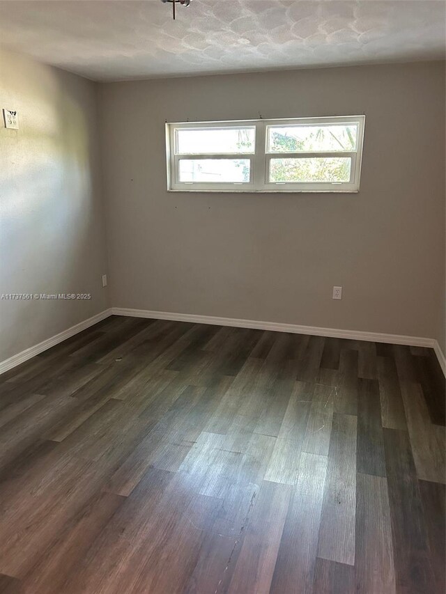 7403 Foxbloom Dr, New Port Richey, FL 34668 - unfurnished room featuring healthy amount of natural light, baseboards, and dark wood finished floors