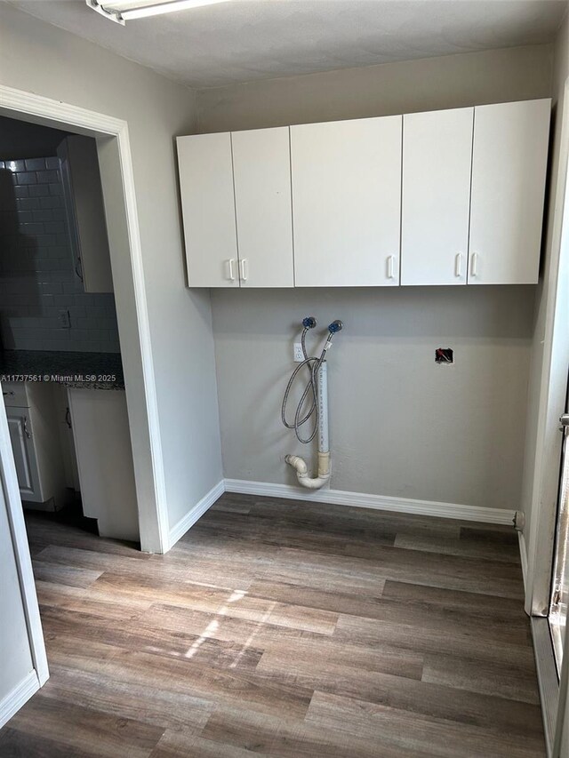 7403 Foxbloom Dr, New Port Richey, FL 34668 - washroom with wood finished floors, washer hookup, baseboards, and cabinet space