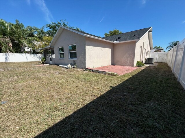 7403 Foxbloom Dr, New Port Richey, FL 34668 - view of side of property with central AC unit, stucco siding, and a patio area