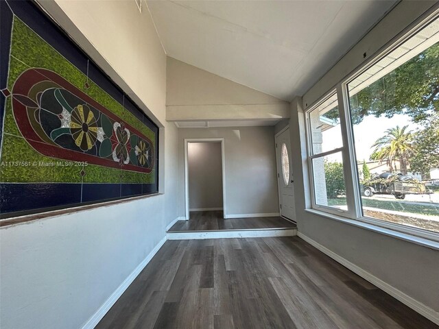 7403 Foxbloom Dr, New Port Richey, FL 34668 - foyer featuring wood finished floors, vaulted ceiling, and baseboards