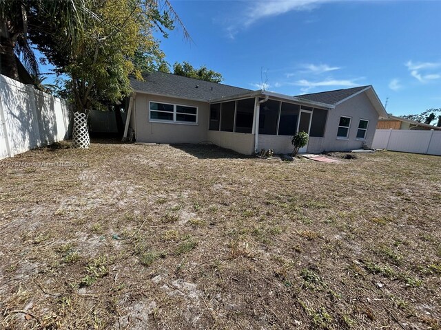 7403 Foxbloom Dr, New Port Richey, FL 34668 - rear view of property with a fenced backyard and a sunroom