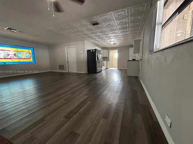 7403 Foxbloom Dr, New Port Richey, FL 34668 - unfurnished living room with baseboards, dark wood-style flooring, ceiling fan, and an ornate ceiling