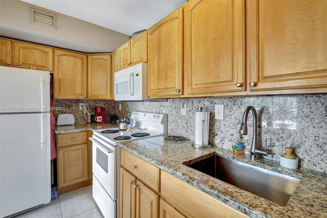 kitchen with light tile patterned flooring, sink, decorative backsplash, light stone counters, and white appliances