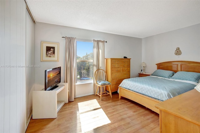 bedroom featuring a textured ceiling and light wood-type flooring