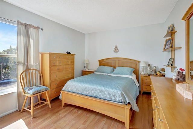 bedroom featuring a textured ceiling and light wood-type flooring