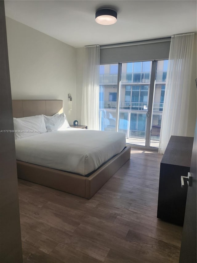 bedroom with dark wood-type flooring and access to outside