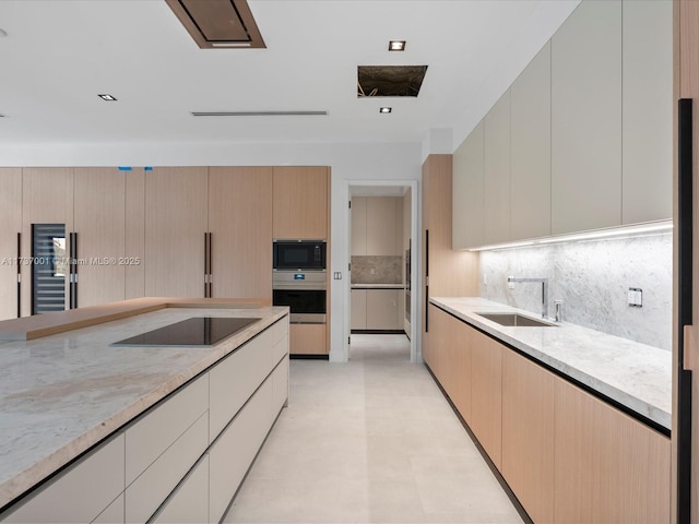 kitchen with light stone countertops, decorative backsplash, black appliances, and light brown cabinets