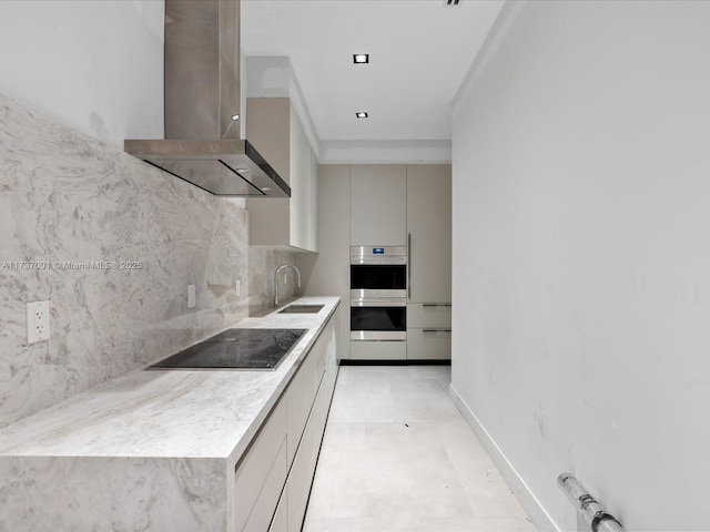 kitchen featuring sink, tasteful backsplash, double oven, black electric stovetop, and wall chimney range hood