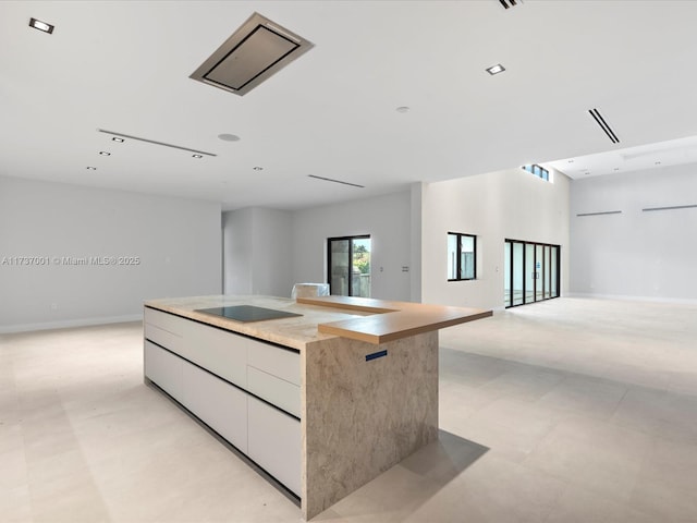 kitchen featuring white cabinetry, black electric stovetop, and a kitchen island