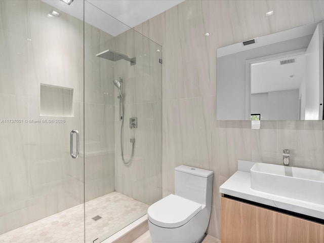 bathroom with tile walls, backsplash, vanity, toilet, and a shower with door