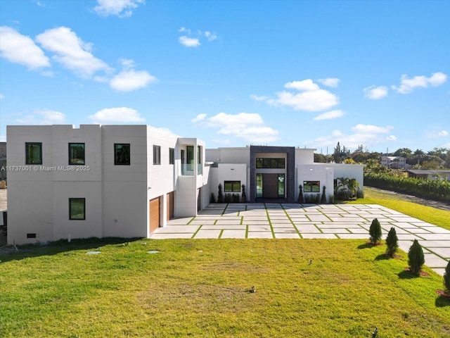 back of property featuring a garage and a lawn