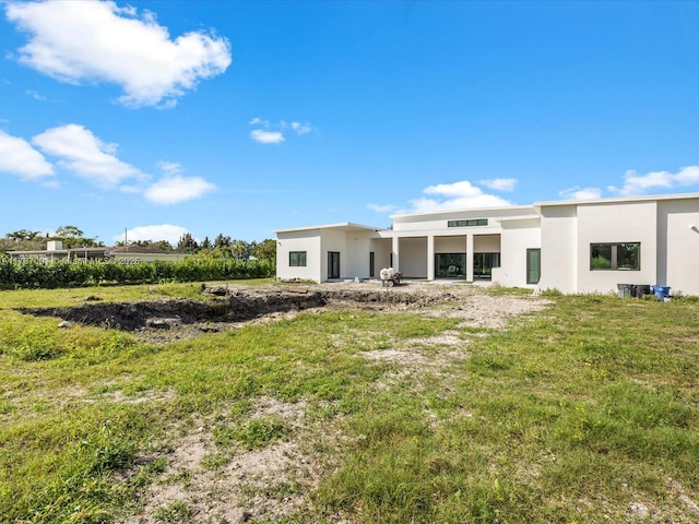 rear view of house featuring a lawn