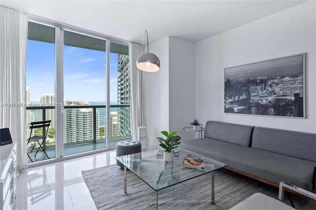 living room with floor to ceiling windows, a water view, and tile patterned floors