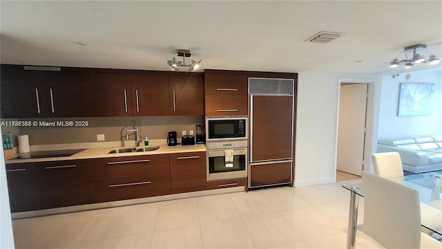 kitchen with dark brown cabinets, sink, and black appliances