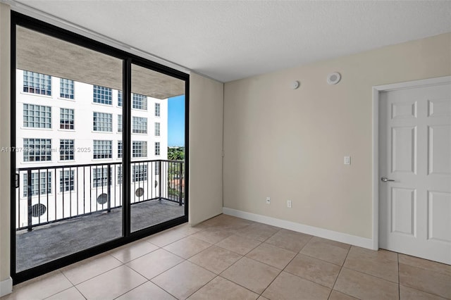 55 Merrick Way Unit 624, Coral Gables, FL 33134 - unfurnished room with light tile patterned flooring, baseboards, a textured ceiling, and a wall of windows