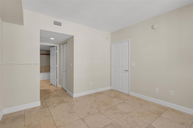 spare room with light tile patterned floors, baseboards, and visible vents