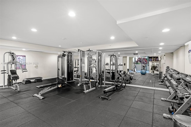 workout area featuring a tray ceiling and recessed lighting