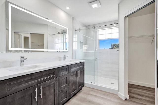 bathroom featuring a shower with door, wood-type flooring, and vanity