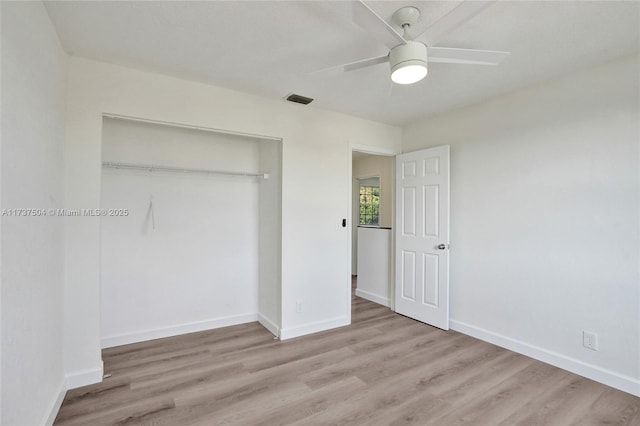 unfurnished bedroom with ceiling fan, light wood-type flooring, and a closet