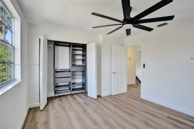 unfurnished bedroom featuring a closet, ceiling fan, and light hardwood / wood-style flooring