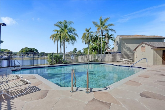 view of swimming pool featuring a water view and a patio area