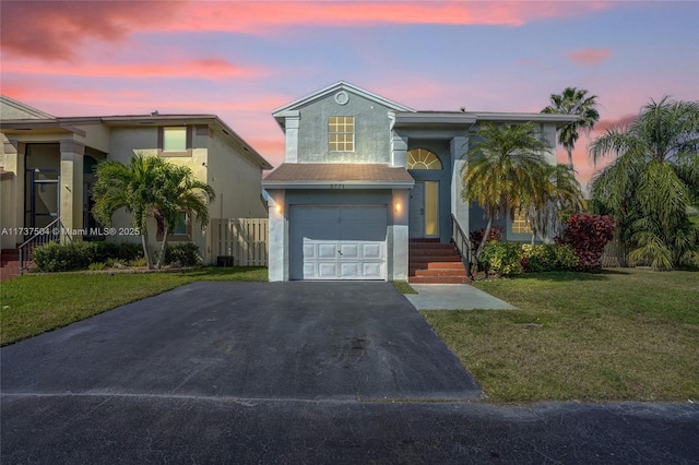 view of front of property with a garage and a yard