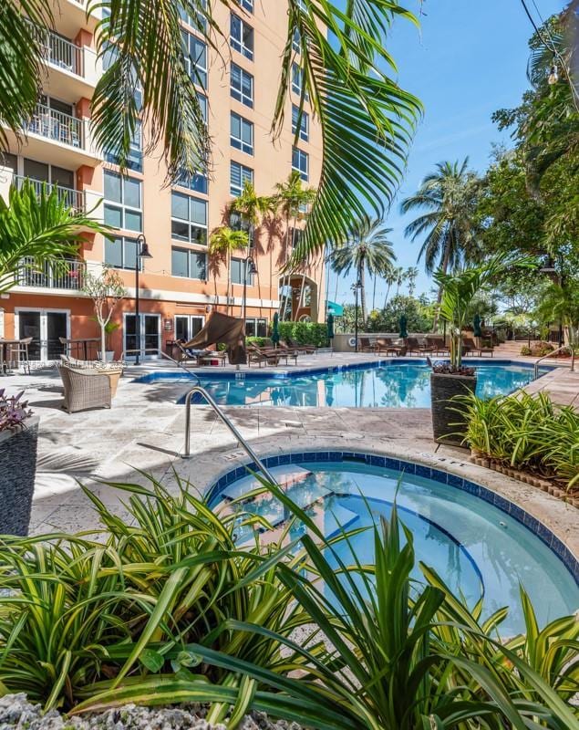 view of swimming pool featuring a hot tub and a patio area