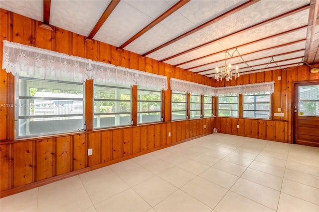 unfurnished sunroom featuring beamed ceiling and a notable chandelier