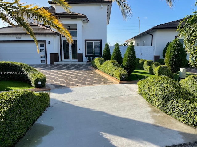 10290 SW 7th Ter, Sweetwater, FL 33174 - view of front of property featuring stucco siding, french doors, an attached garage, and decorative driveway