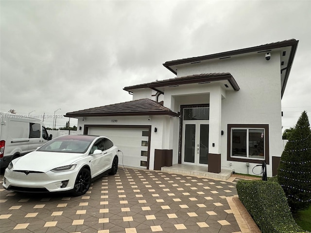 10290 SW 7th Ter, Sweetwater, FL 33174 - exterior space with an attached garage, stucco siding, french doors, a tile roof, and decorative driveway