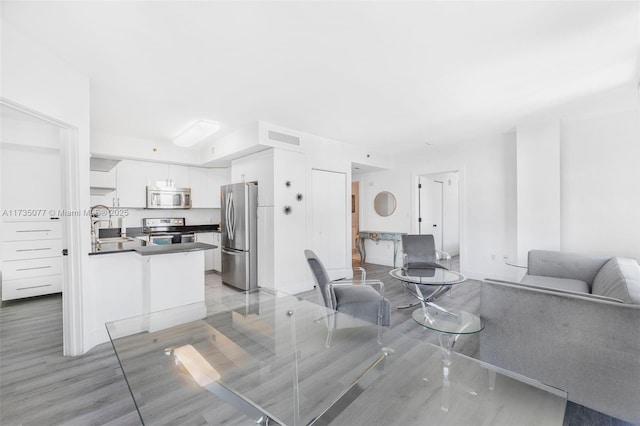 living room with sink and light hardwood / wood-style flooring