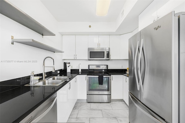 kitchen with stainless steel appliances, sink, and white cabinets