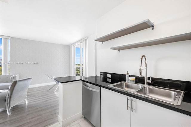 kitchen featuring white cabinetry, dishwasher, sink, and light hardwood / wood-style floors