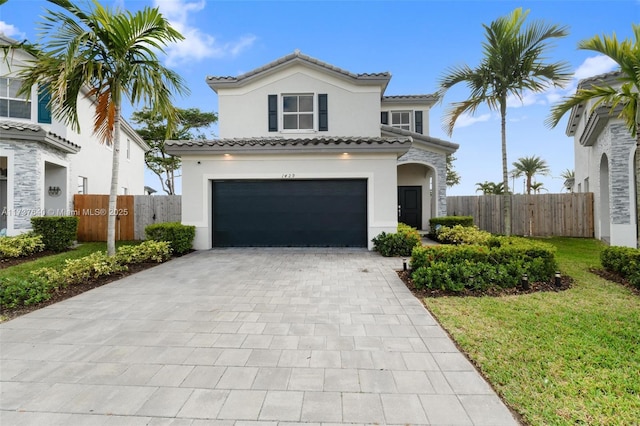 mediterranean / spanish home with a garage and a front lawn