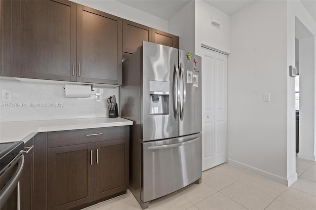 kitchen with dark brown cabinetry, light tile patterned flooring, and appliances with stainless steel finishes