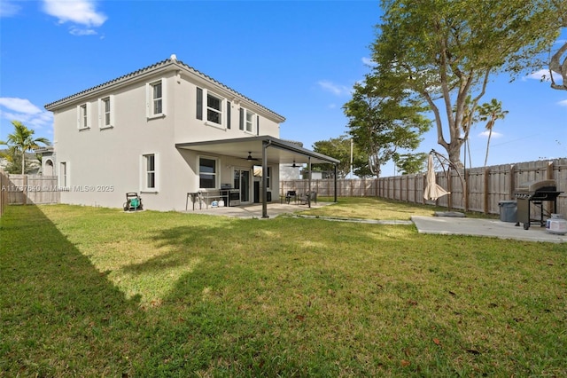 rear view of house with a patio, a yard, and ceiling fan