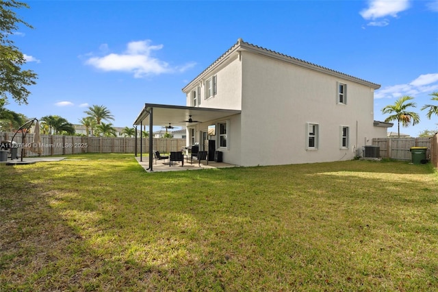 rear view of property with central AC, ceiling fan, a patio, and a lawn