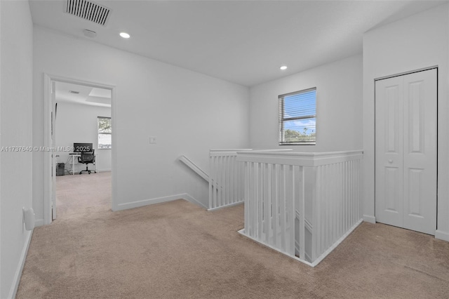 corridor featuring a healthy amount of sunlight and light colored carpet