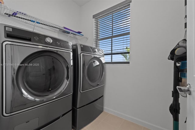 laundry area with separate washer and dryer and light tile patterned floors