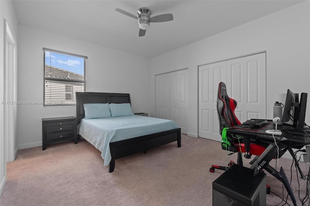 carpeted bedroom with ceiling fan and multiple closets