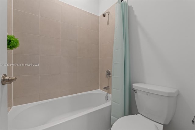 bathroom with tiled shower / bath combo and toilet