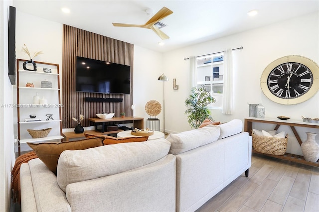 living room with light hardwood / wood-style flooring and ceiling fan