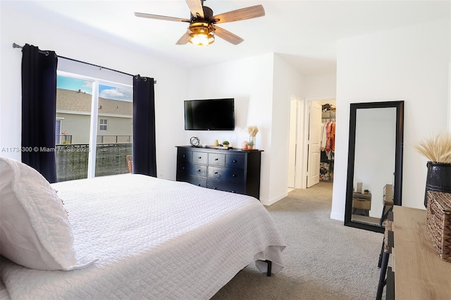 bedroom with a spacious closet, light carpet, access to exterior, and ceiling fan