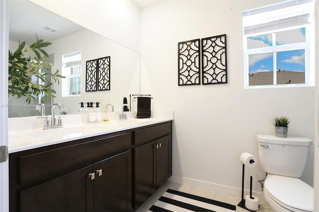 bathroom featuring vanity, tile patterned flooring, and toilet