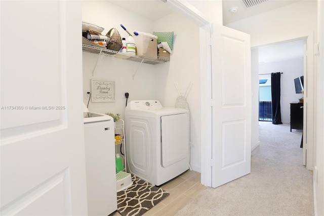 laundry area with light colored carpet and washer and clothes dryer