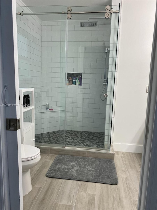 bathroom featuring an enclosed shower and toilet