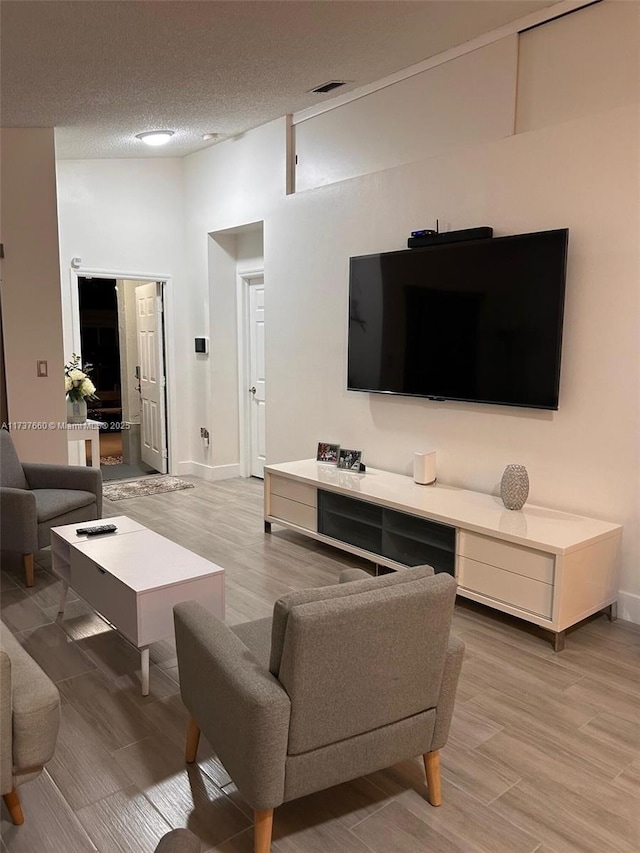 living room featuring light hardwood / wood-style floors and a textured ceiling