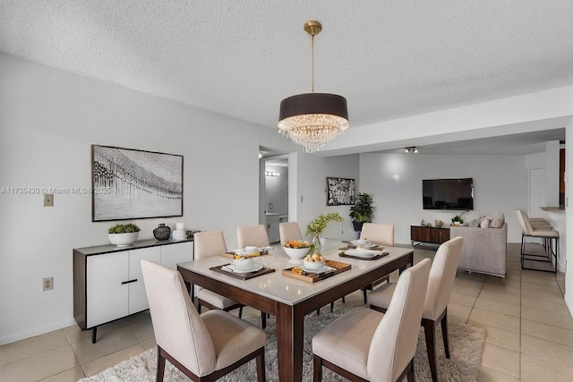 dining room with light tile patterned floors, a chandelier, and a textured ceiling